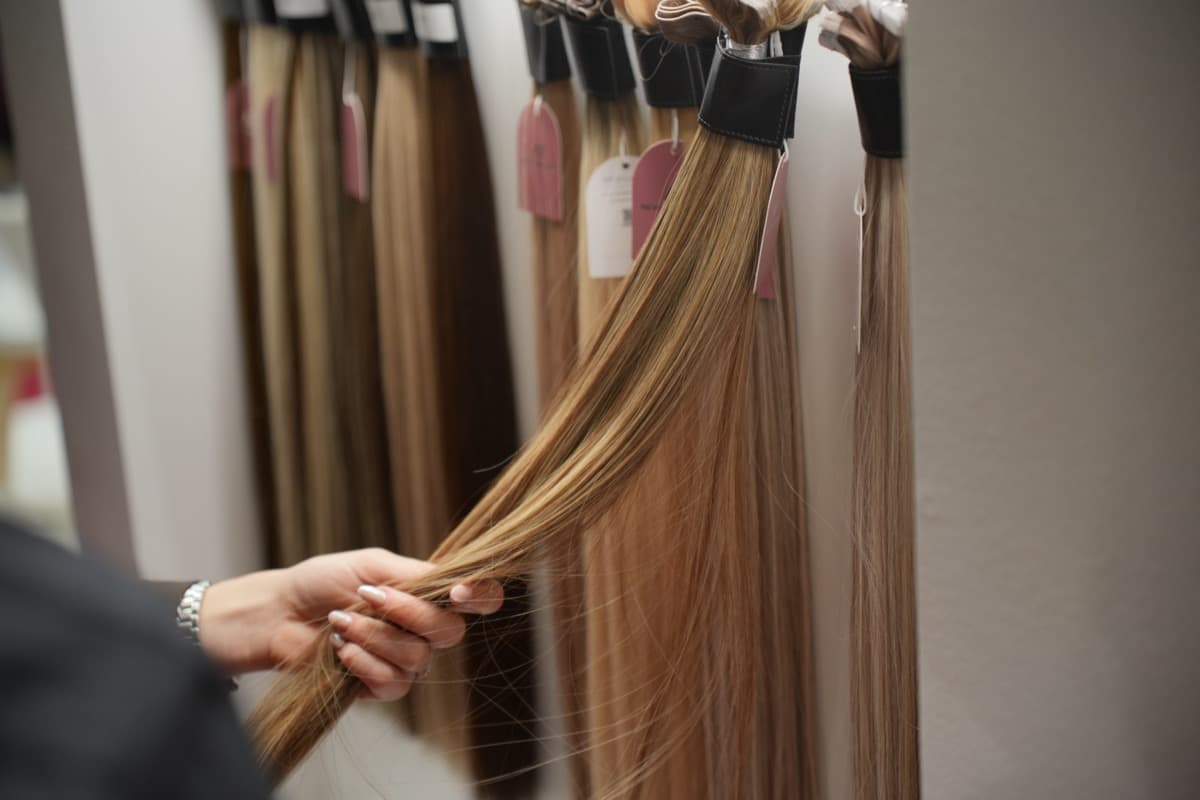 Stylist holding a long hair extension sample