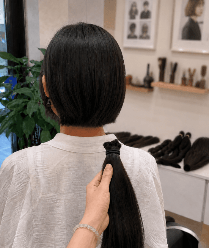 Hair donor holding a collected hair bundle