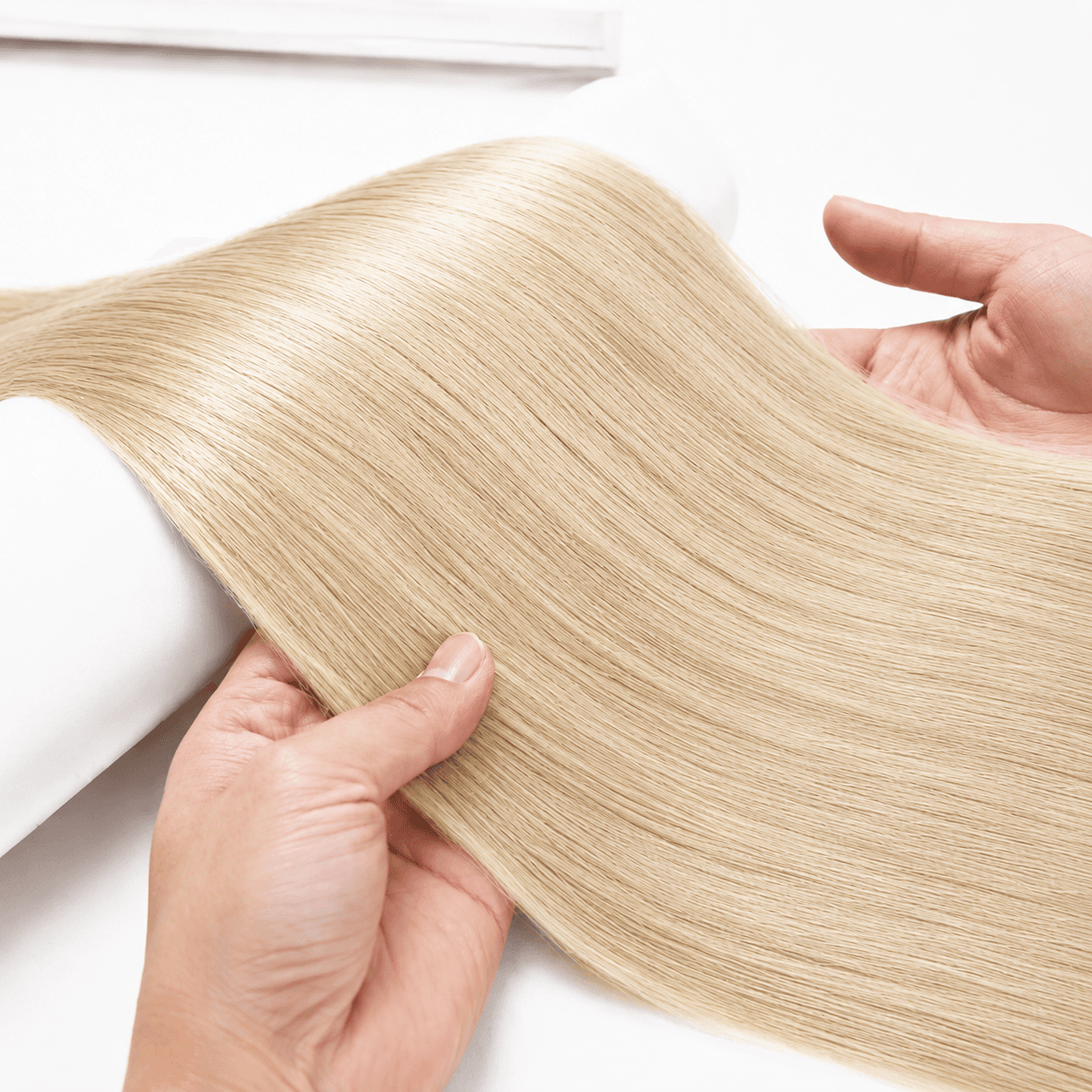 Blonde hair extension spread out for fullness inspection