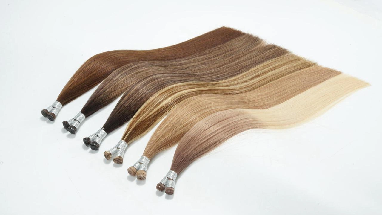 Genius Weft Remy human hair extensions in brown, balayage, and blonde shades, shown as thin, flat, lightweight weft options for fine-hair salon clients.