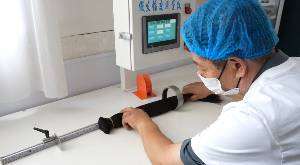 ESSMEI factory quality inspector measuring the hair extension fullness with a precision equipment.
