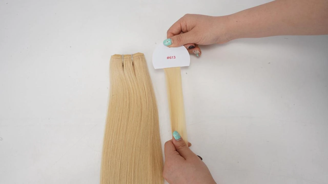 Hair extension color consistency check for salons, showing #613 blonde extensions compared against a standard color ring before bulk ordering.
